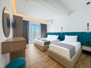 a hotel room with two beds and a television at Zace Studios in Ksamil