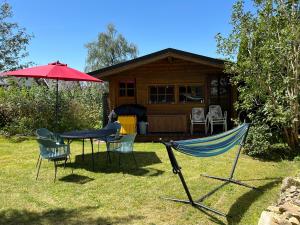 a table and chairs in front of a cabin at Ferienwohnung 1 Klangweberei im Frankenwald in Helmbrechts