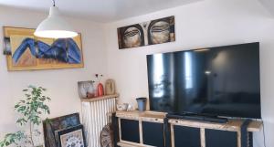 a living room with a large flat screen tv at LIKE HOME - Comme Chez Soi - Chambre d'hôte in Saint Lo