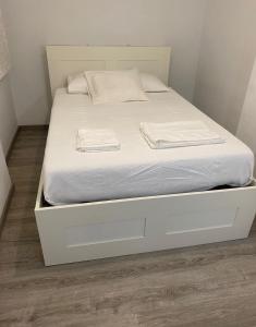 una cama blanca con cajones blancos y sábanas blancas en Departamento en Torrent, en Torrent