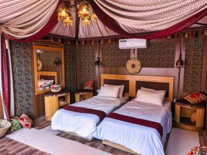 a bedroom with two beds and a mirror at Wadi Rum Majestic Camp in Wadi Rum