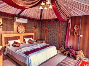 a bedroom with a bed in a tent at Wadi Rum Majestic Camp in Wadi Rum