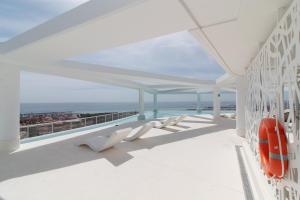 einen Balkon mit weißen Stühlen und Meerblick in der Unterkunft Gran Canet Vlado in Canet d'en Berenguer
