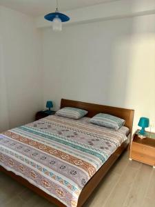 a bed in a bedroom with two night stands and two lamps at Coast line apartment Mika in Tivat