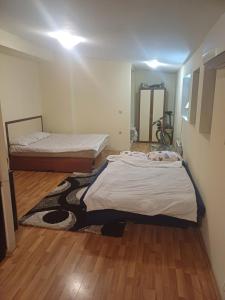 a bedroom with two beds and a wooden floor at Апартамент студио в затворен комплекс в гр.Банско in Bansko