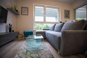a living room with a couch and a glass coffee table at Aurora, Banská Bystrica in Banská Bystrica