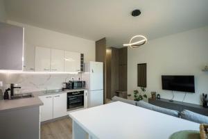 a kitchen and living room with white cabinets at Aurora, Banská Bystrica in Banská Bystrica