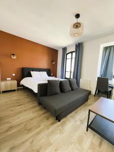 ein Schlafzimmer mit einem Bett und einer Couch in der Unterkunft villa Konny studio 1er étage in Le Tréport