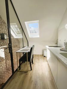 eine Küche mit einem Tisch und einer Ziegelwand in der Unterkunft villa Konny studio 1er étage in Le Tréport