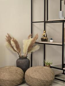a room with two stools and a vase with feathers at Maggie's Blissful Escape in Loutraki