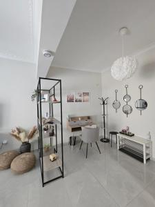a white living room with a mirror and a chair at Maggie's Blissful Escape in Loutraki