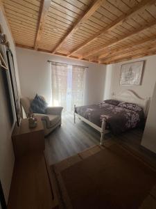 a bedroom with a bed and a couch and a window at Casa do avô Serafim in Cetos +37 photos