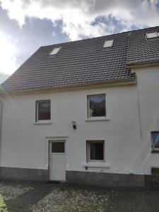 a white house with a black roof at Ferienhaus Salmtal Himmerod in Großlittgen