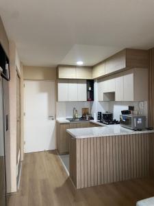 a kitchen with white cabinets and a counter top at Entire Apartment 20 min from airport - Cozy and Secure in Lima