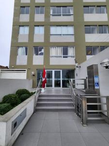 a building with stairs and a flag in front of it at Entire Apartment 20 min from airport - Cozy and Secure in Lima