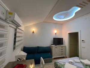 a living room with a blue couch and a tv at Laguna apartment in Tivat