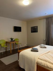 a bedroom with a bed and a table and a television at Hotelli Keskipiste in Kärsämäki