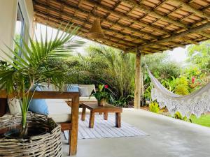 un patio con hamaca, mesa y banco en Casa Safyra, en Caraíva