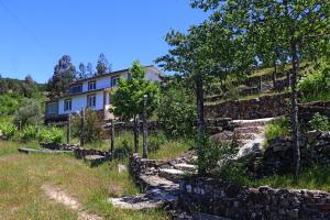 a house on a hill with rocks and trees at Casa do Monte 2 in Castro Daire