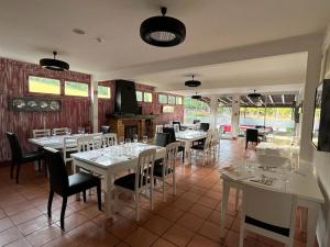 un ristorante con tavoli e sedie bianchi e finestre di Classic Car House a Santa Cruz