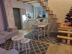 a kitchen and living room with a table and chairs at Kwiatowy domek in Zatory +7 photos