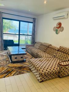 a living room with a couch and a table at Relax Oceanfront Suites in Sere Kunda