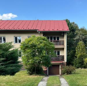 a house with a red roof and a yard at Apartman na konci světa Hřensko in Hřensko