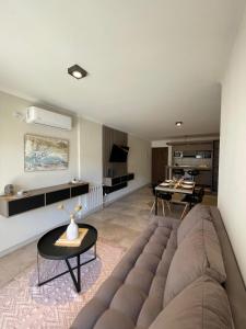 a living room with a couch and a table at Depto "Ideal" Céntrico, Pile Climat y Pile en Terraza, Cochera, Calef Central in Villa Carlos Paz +16 photos