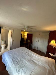 a bedroom with a large white bed and a bathroom at Gaard motel in Foxborough