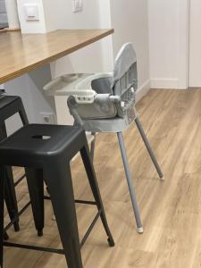 a gray high chair next to a table and a black stool at LAR DE SEFA in Redondela
