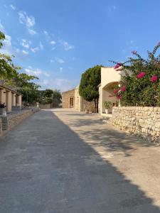 an empty road with a stone wall and a building at Il Carosello dei Baroni in Noto