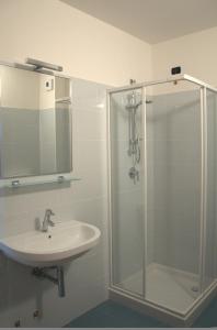 La salle de bains est pourvue d'une douche en verre et d'un lavabo. dans l'établissement Hotel Motel Galaxy Reggio Emilia, à Reggio d'Émilie