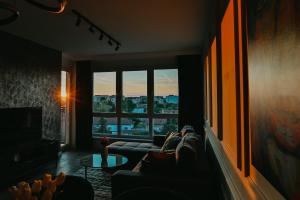 a living room with a couch and a large window at Tara View Apartment in Subotica