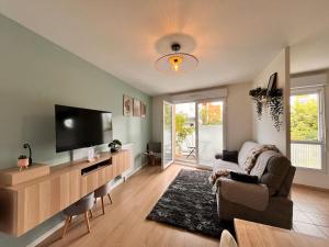 a living room with a television and a couch at Appartement Saint-Denis proche Stade de France in Saint-Denis