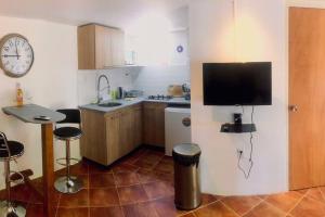 Il comprend une cuisine avec un évier et une télévision murale. dans l'établissement Beautiful apartment, à Willemstad