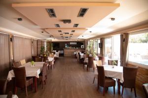 a dining room with white tables and chairs at Hotel Istatov in Nov Dojran