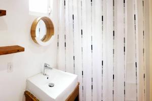 bagno con lavandino e tenda da doccia bianca di Cozy apartment a Willemstad Altre 21 foto