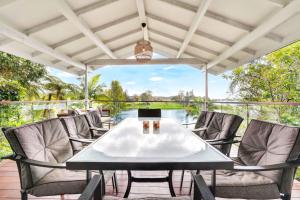 a patio with a table and chairs on a deck at LakeSide Tinaroo only 2.5km from Yungaburra town in Yungaburra
