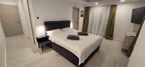 a bedroom with a large bed with two pillows on it at Casa de la Lac in Baloteşti +30 photos