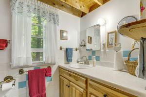une salle de bain avec un lavabo et une fenêtre dans l'établissement Quiet and Remote Cottage on Panther Pond!, à Raymond 21 autres photos