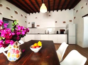 a kitchen with a wooden table with a vase of flowers at Los Nopales Fuerteventura in Antigua