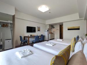 a hotel room with two beds and a kitchen at ESLEAD HOTEL Namba Ebisu West in Osaka