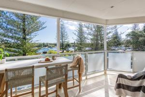 Un comedor con mesa y sillas y grandes ventanales. en Penthouse on the Ritz - Oceanstays, en Yamba 33 fotos más