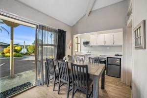 a kitchen and dining room with a table and chairs at Cameron Road Motel in Tauranga
