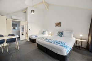 a hotel room with two beds and a table at Cameron Road Motel in Tauranga