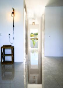 een gang met een badkamer met douche en een raam bij Tiki Blou - Mini resort centraal gelegen tussen Mambo Beach & Jan Thiel in Willemstad +32 foto's