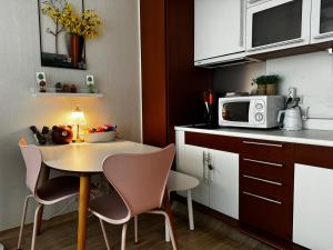 une petite cuisine avec une table, des chaises et un micro-ondes dans l'établissement If House Hongdae, à Séoul 14 autres photos