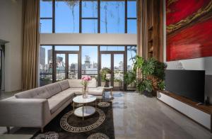 a living room with a couch and a large window at Tashi Oasis Hotel & Apartment Da Nang in Da Nang