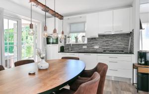 a kitchen with a wooden table and chairs at 3 Bedroom Stunning Home In Hoge Hexel in Hoge-Hexel