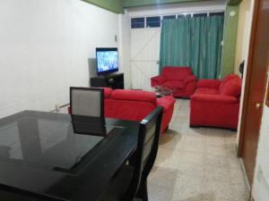 - un salon avec un canapé rouge et deux fauteuils rouges dans l'établissement El Refugio, à Oaxaca